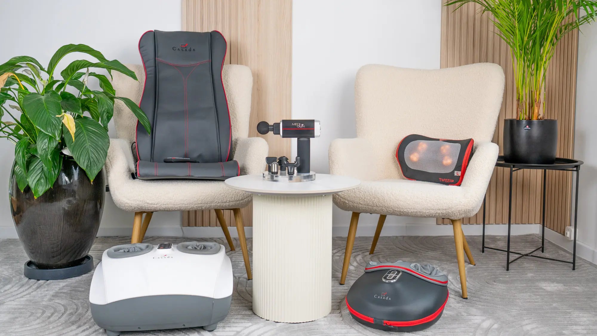 Zdjecie przedstawia zestaw produktów marki Casada: matę masującą, poduszkę masującą, masażery stóp i pistolet wibracyjny. 